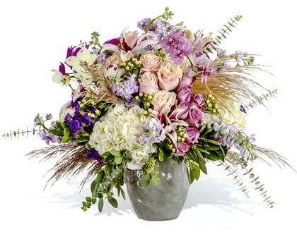 A fragrant arrangement of orchids, roses and hydrangea with plenty of flourish and style.