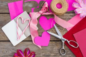 Pink construction paper, twine, and scissors for a cute Valentine's Day craft.